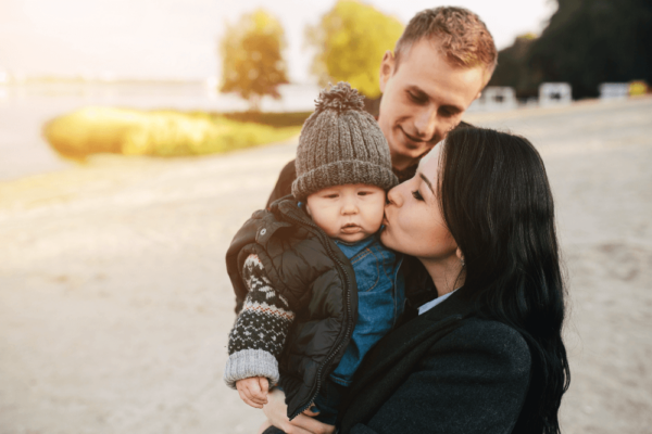 adoptive parents smile with their adopted newborn child